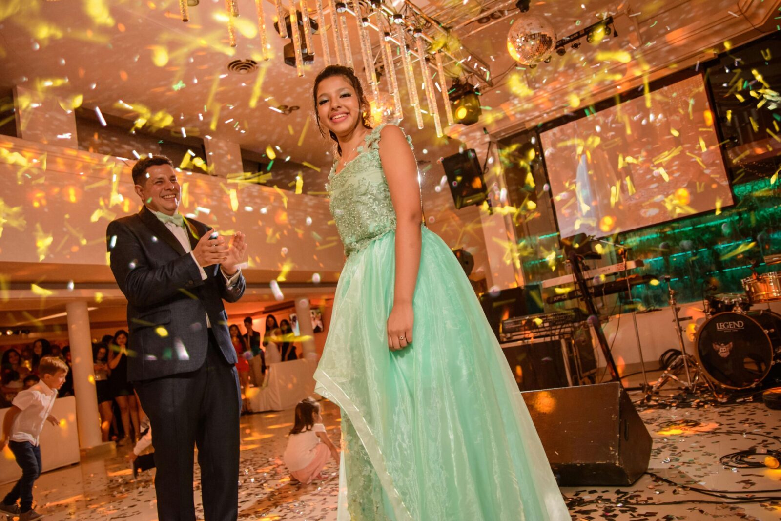 Adults enjoying a lively indoor party with confetti and lights.