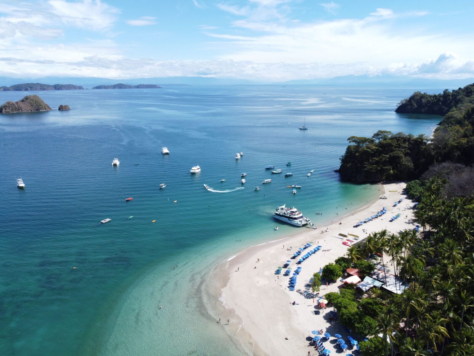 Stunning aerial view of Playa Blanca with boats and lush greenery in Costa Rica's tropical paradise.
